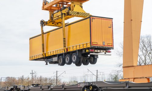 Yellow,Semi-trailer,Being,Lifted,By,A,Gantry,Crane,At,An
